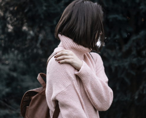 woman with straight bob hair cut in pink sweater
